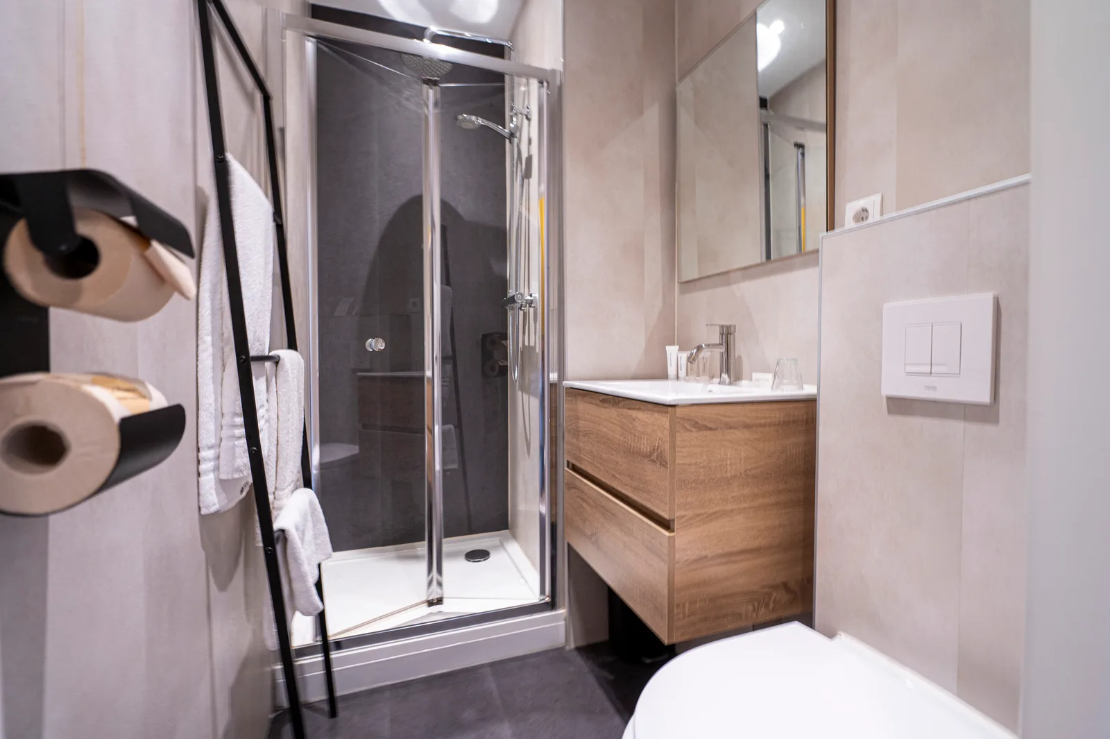 Badkamer met douchecabine, wastafel en handdoekenrek