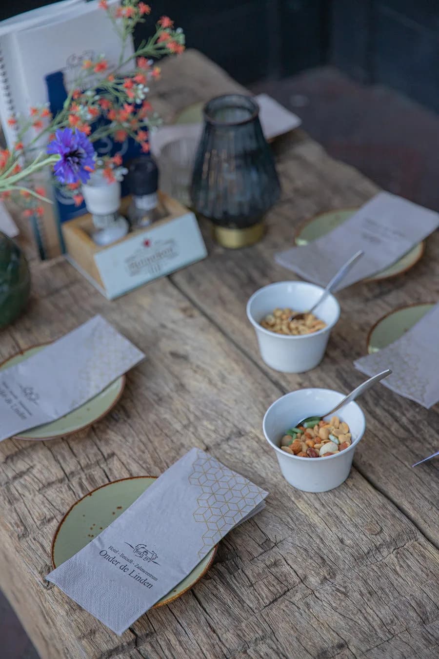 Gedekte tafel met servetten, bloemen en nootjes voor de borrel