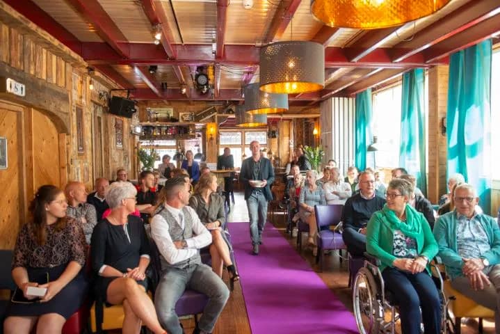 Gasten kijken toe tijdens een ceremonie in De Brasserie