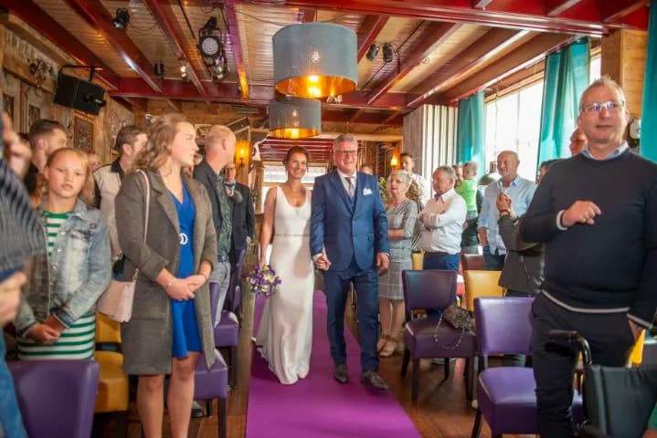 Bruidspaar loopt over de paarse loper door De Brasserie