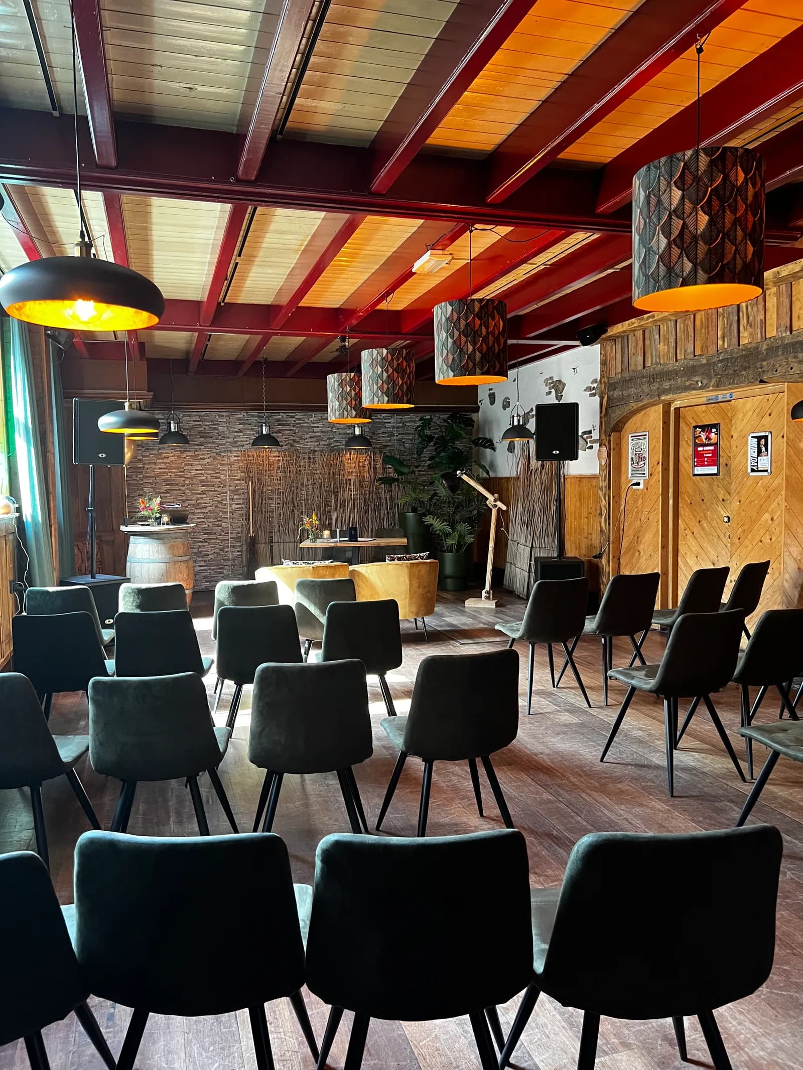 Rijen stoelen opgesteld voor een ceremonie, met de fauteuils en de bar op de achtergrond