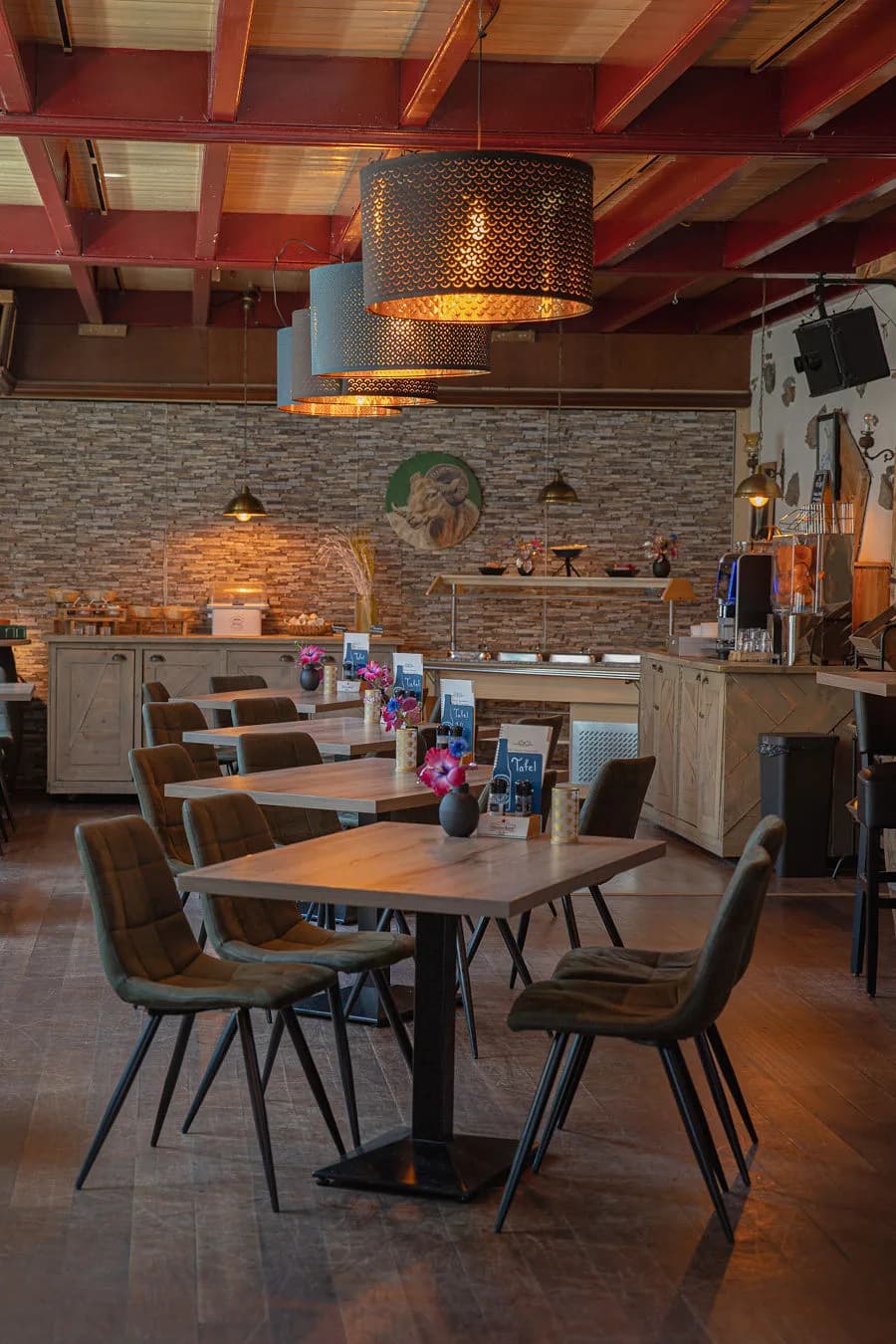 Gedekte tafels in De Brasserie onder de rode balken