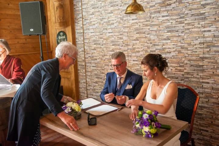 Ondertekening van de trouwakte tegen de natuurstenen wand