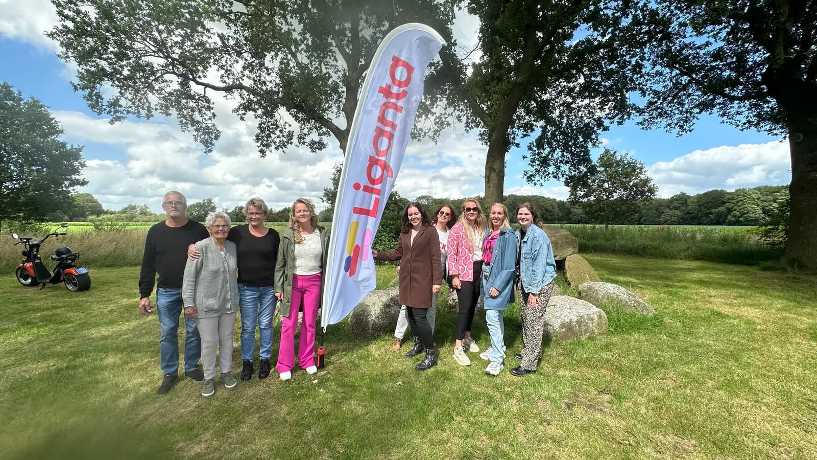 Groep collega’s bij een hunebed in het gras tijdens een bedrijfsdag buiten