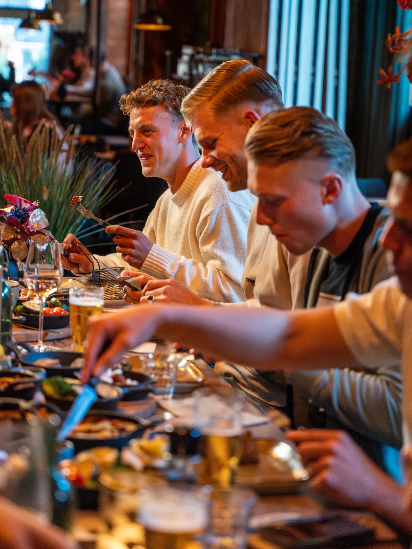 Collega’s eten samen van shared dining aan een lange tafel