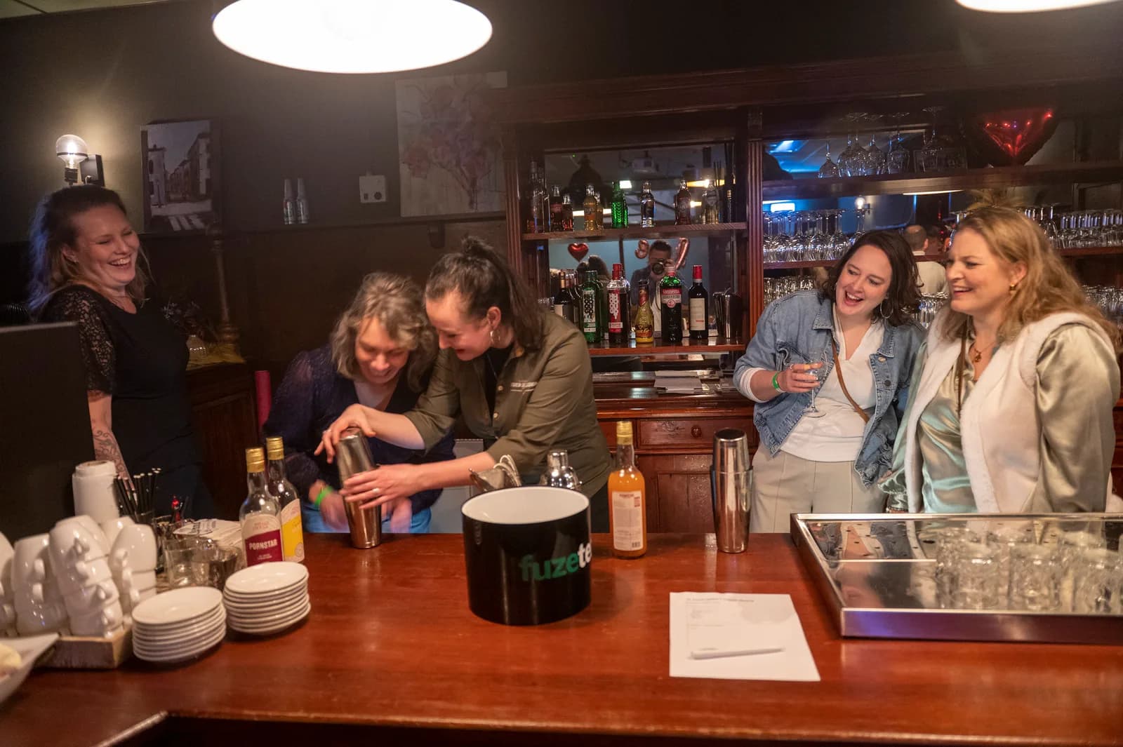 Gasten maken samen cocktails achter de bar