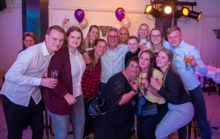 Groepsfoto van feestgangers in de zaal