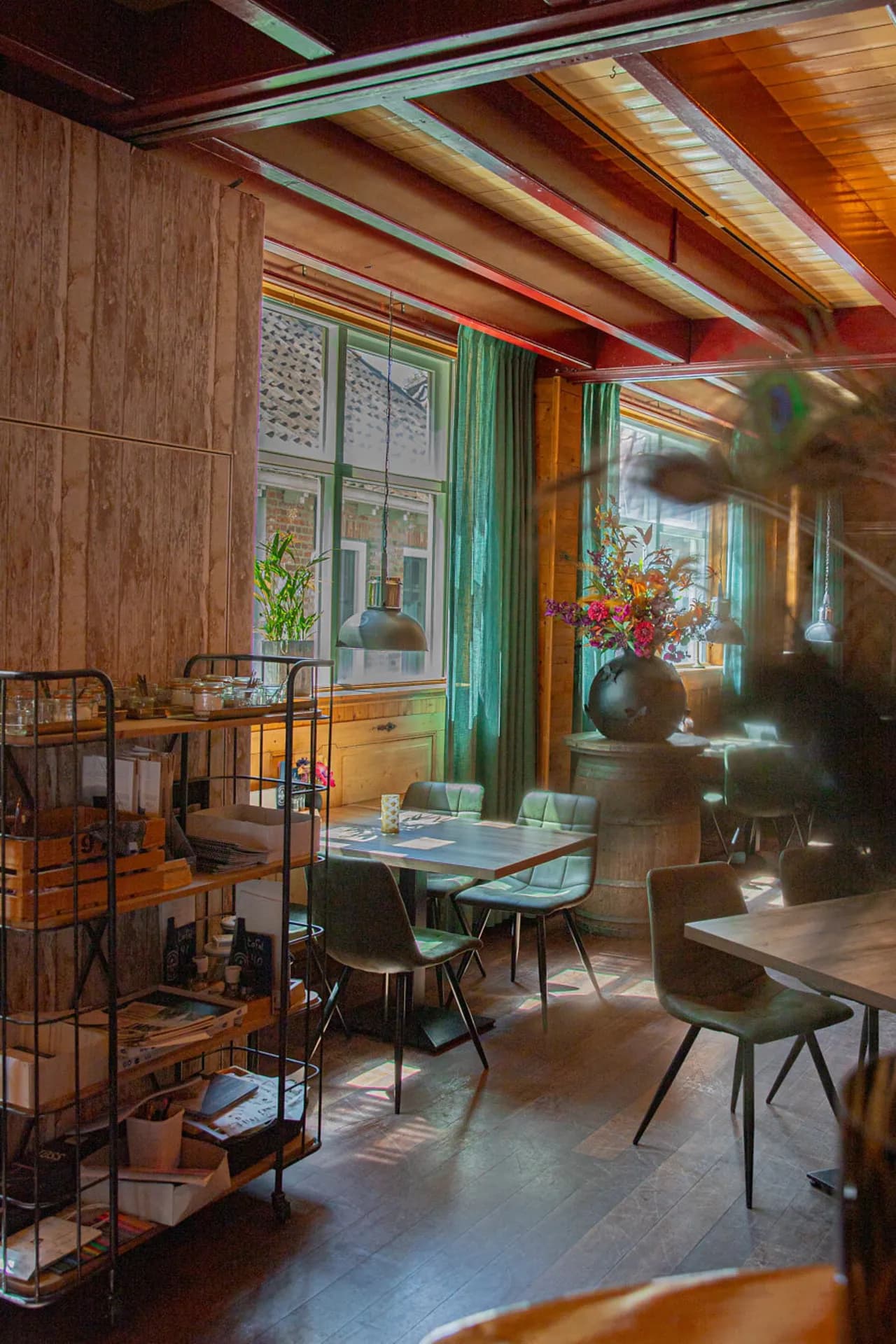 Eethoek in de gastrobar met houten wanden en groene gordijnen