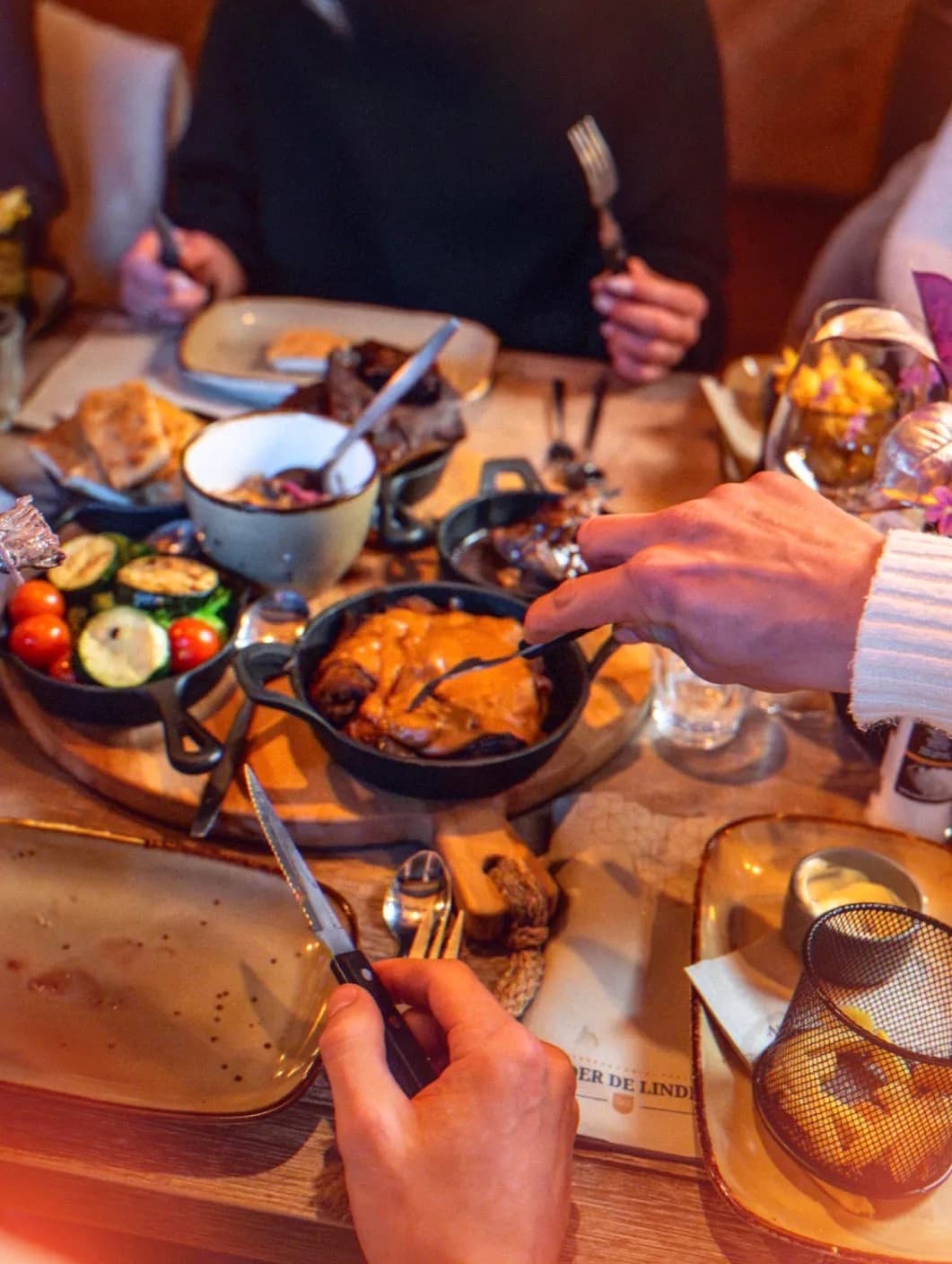 Samen aan tafel met gerechten en gietijzeren pannetjes in de gastrobar