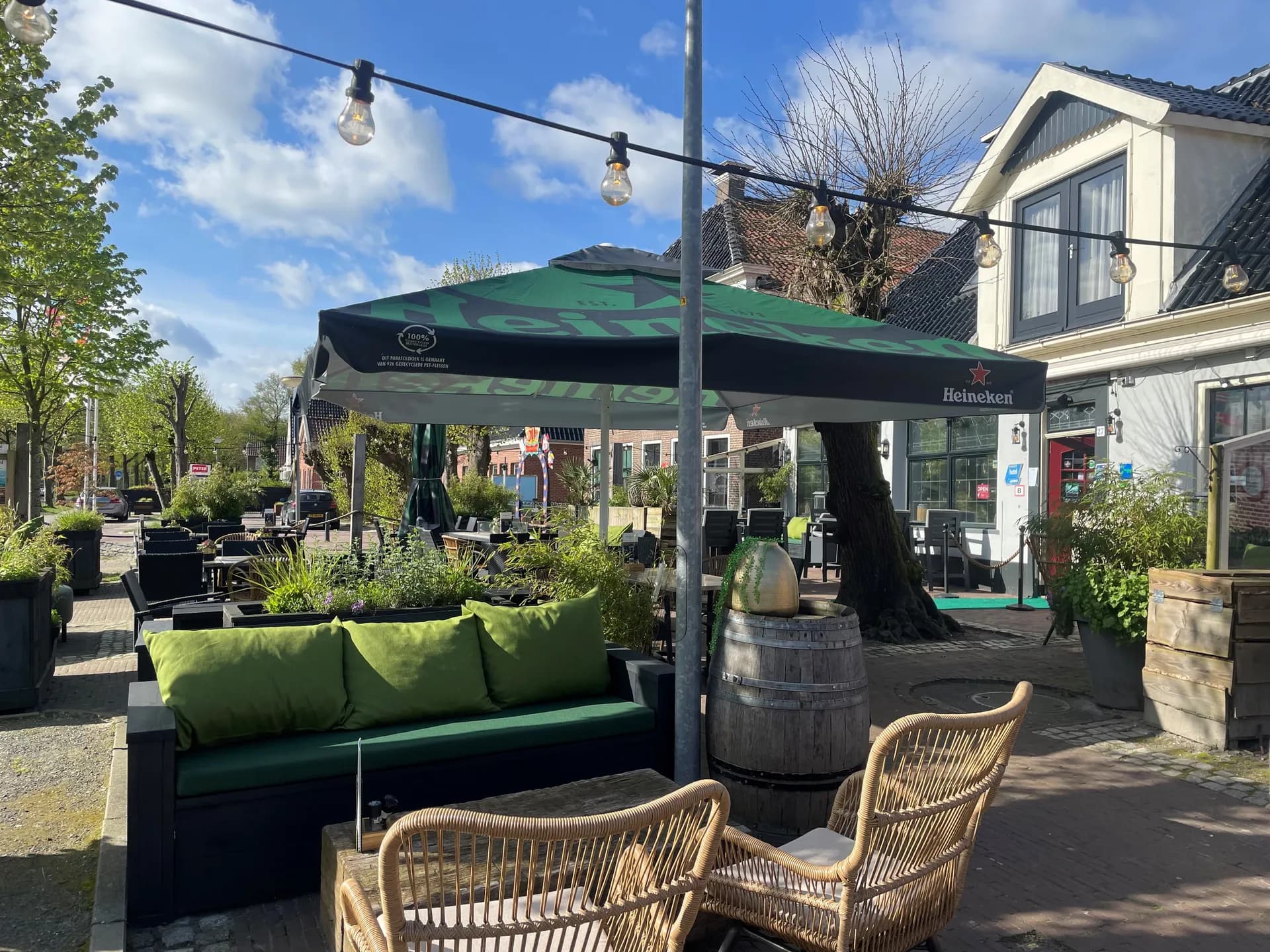 Terras aan de Brink met loungebank, parasol en lichtsnoer