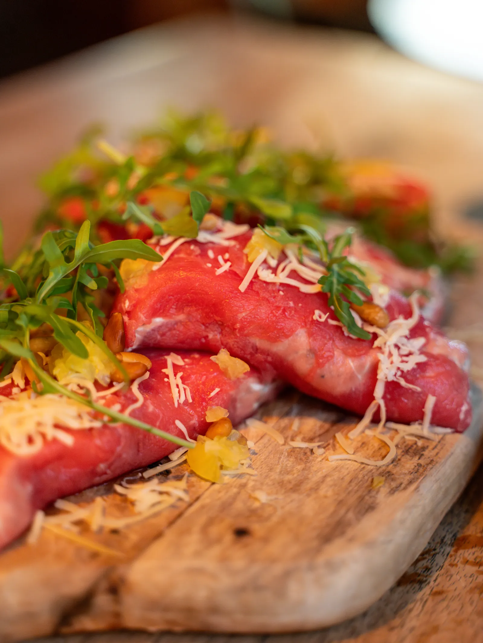 Carpaccio met rucola en parmezaan op een plank