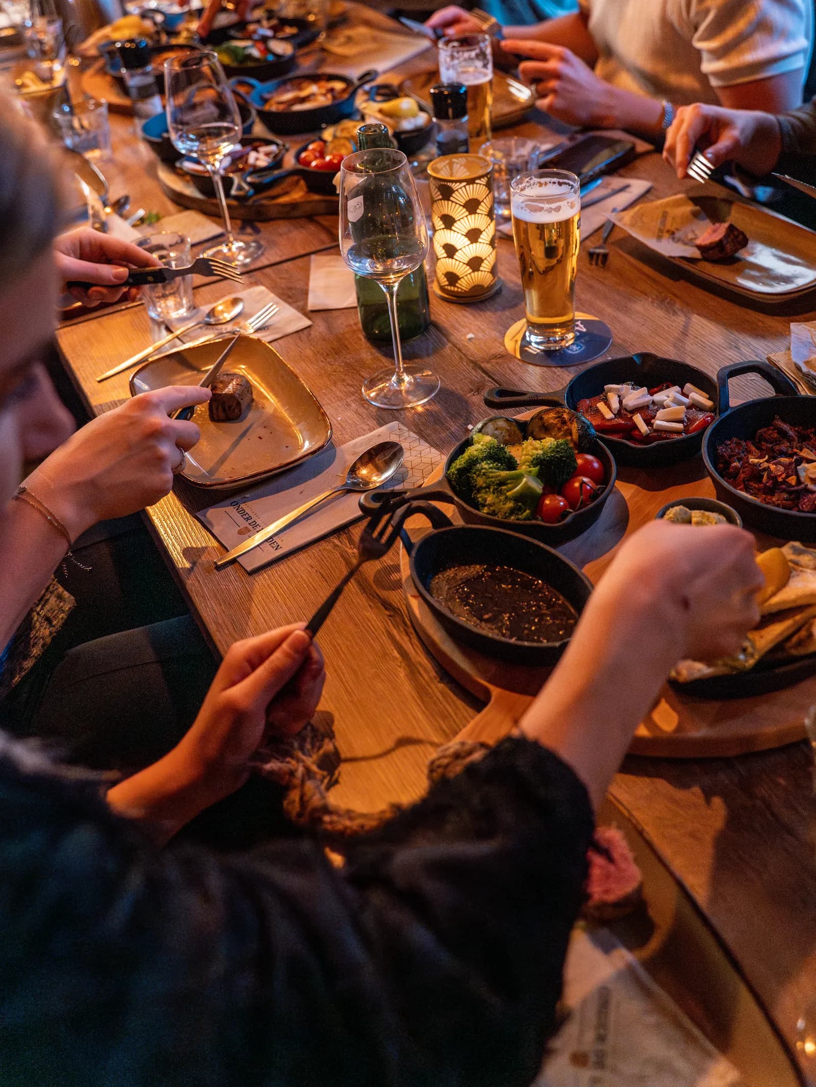 Warme gerechten in pannetjes op een gedekte tafel