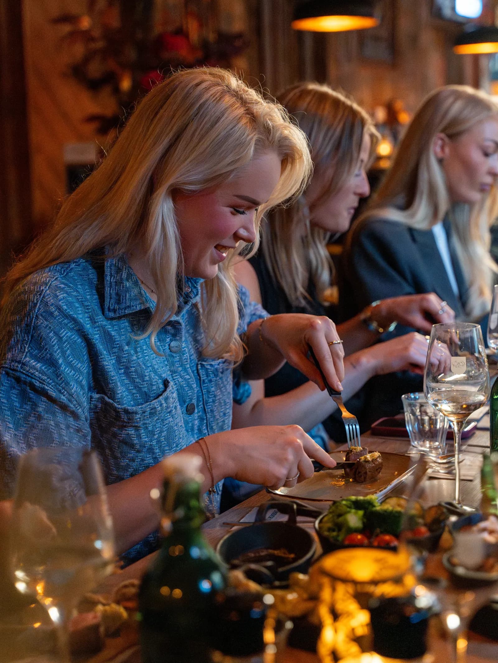 Gezelschap eet en drinkt samen aan een lange tafel in de gastrobar
