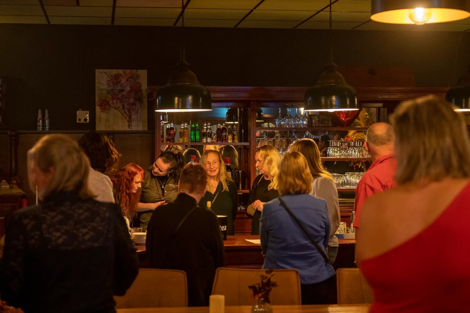 Gasten staan te praten rond de bar van de gastrobar