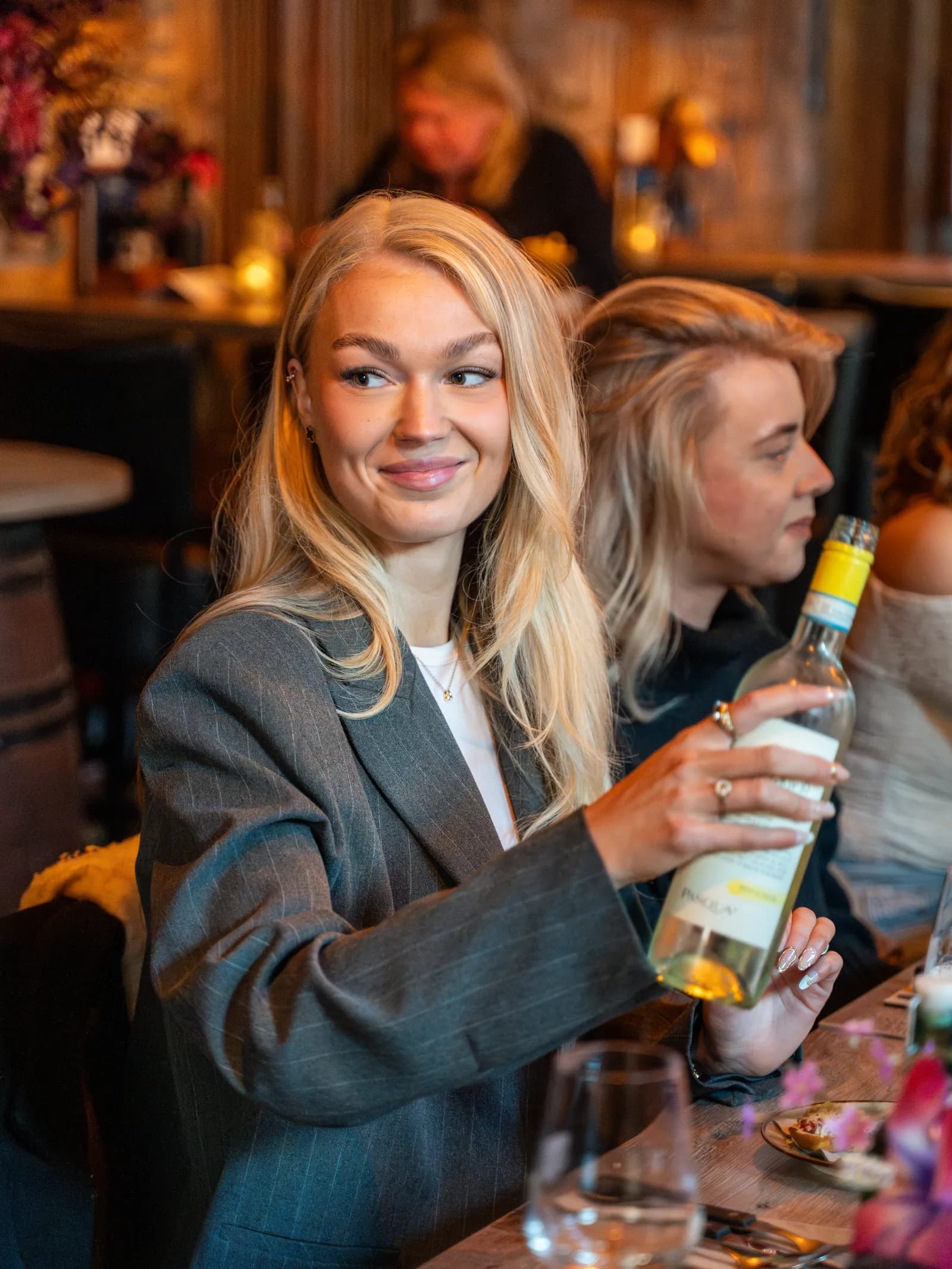 Gast met een fles witte wijn aan tafel in de gastrobar in Roden