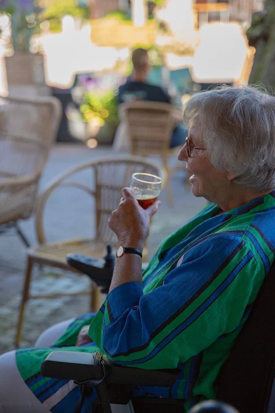 Gast drinkt rosé in een rieten stoel in de avondzon