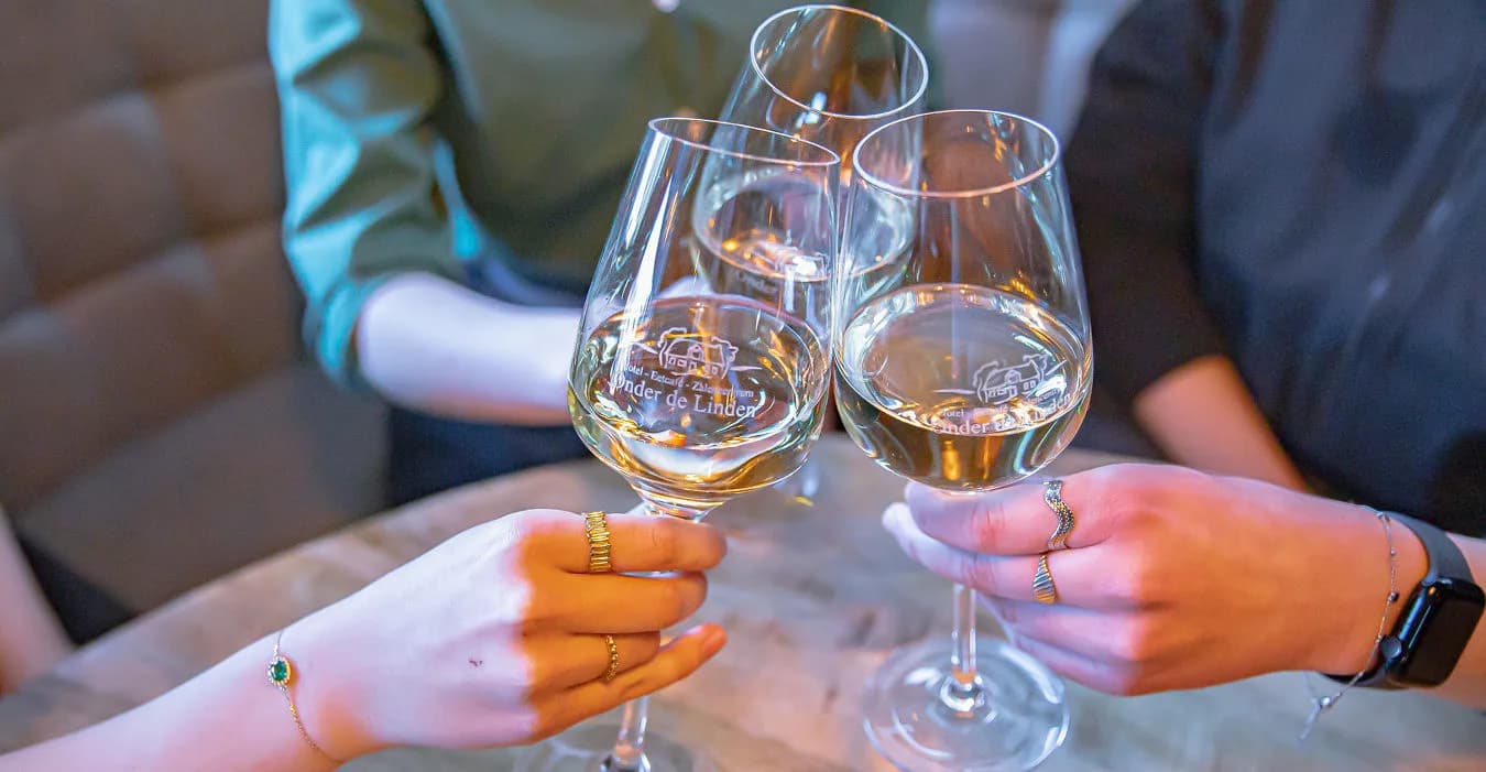 Proosten met glazen witte wijn aan tafel