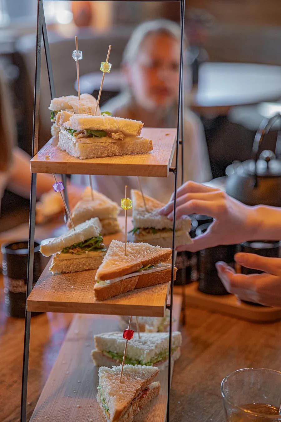 Gasten pakken sandwiches van de etagère aan tafel