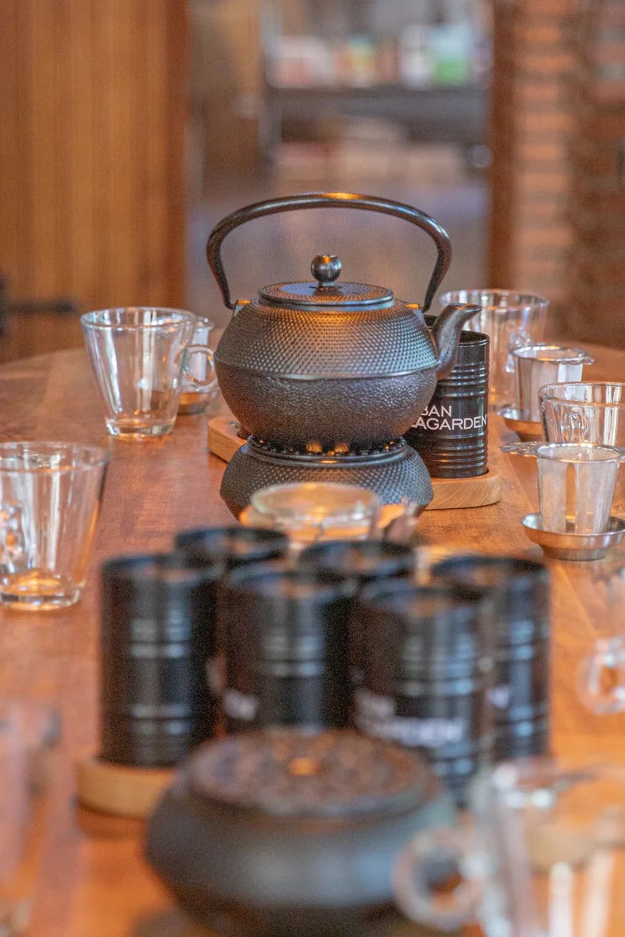 Gietijzeren theepot met glazen en theebusjes op tafel