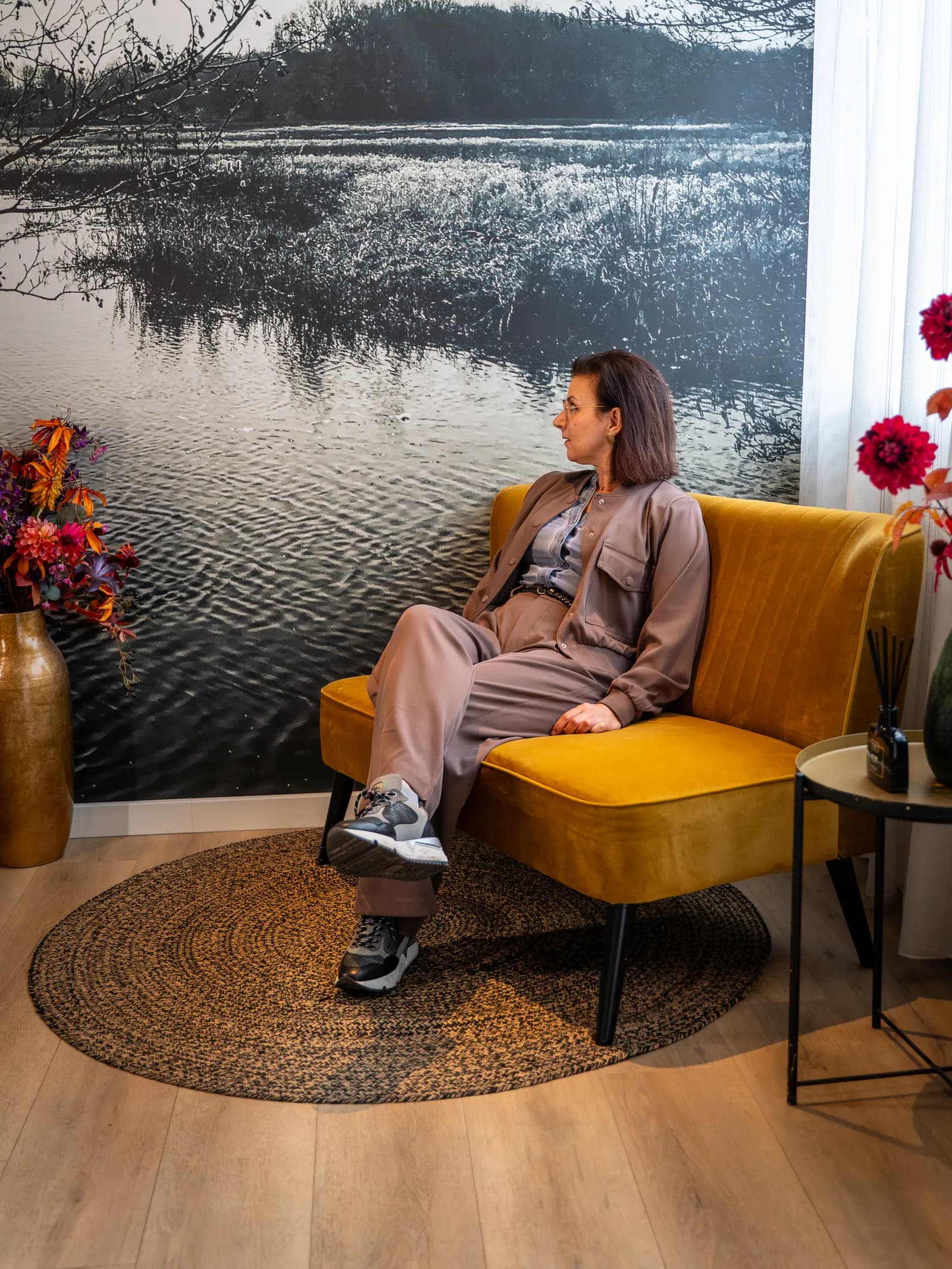 Gast zit in een gele fauteuil bij de fotowand