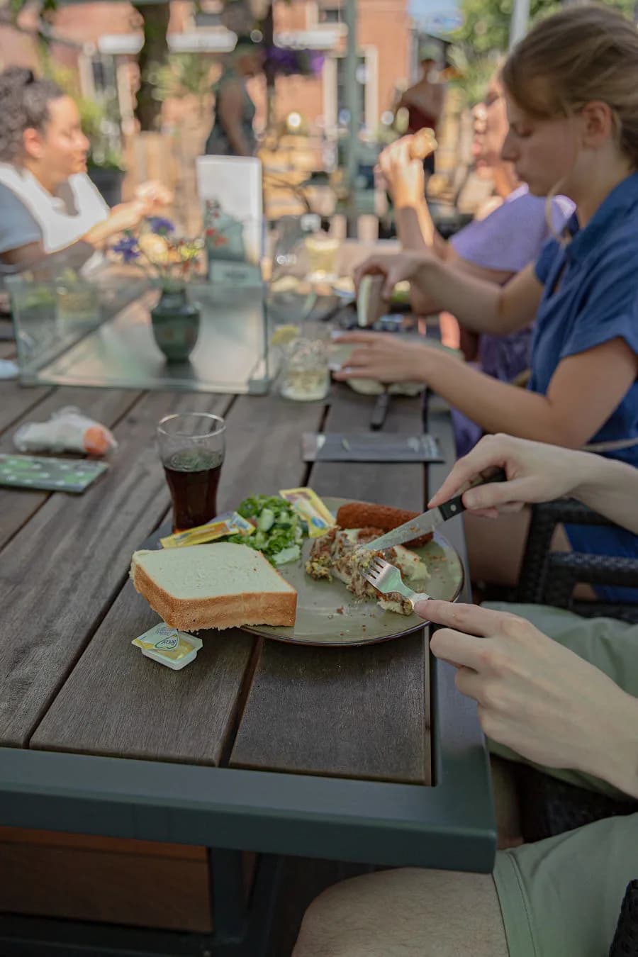 Lunchbord met kroket, salade en brood aan een terrastafel