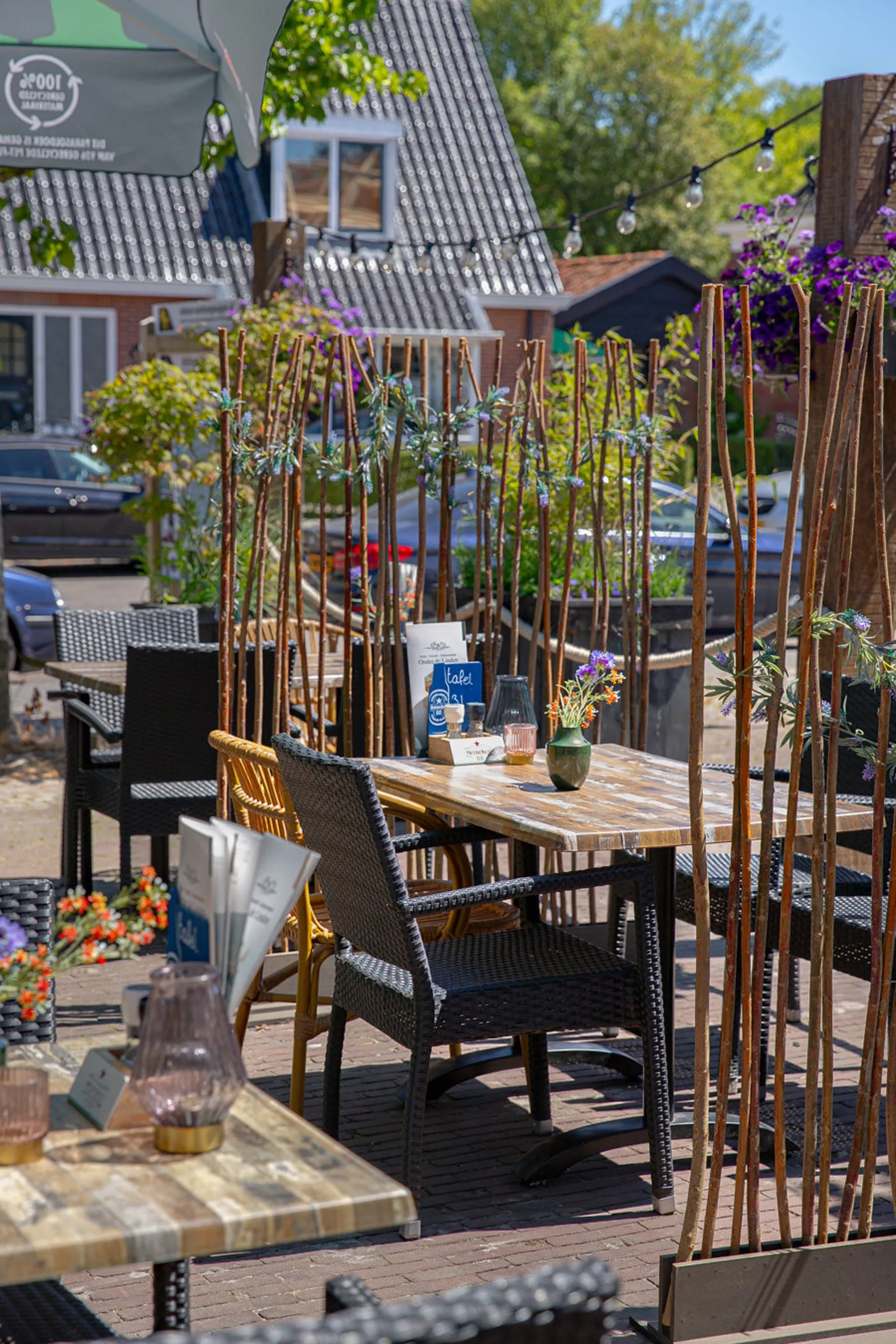 Terrastafels in de zon met dorpshuizen op de achtergrond