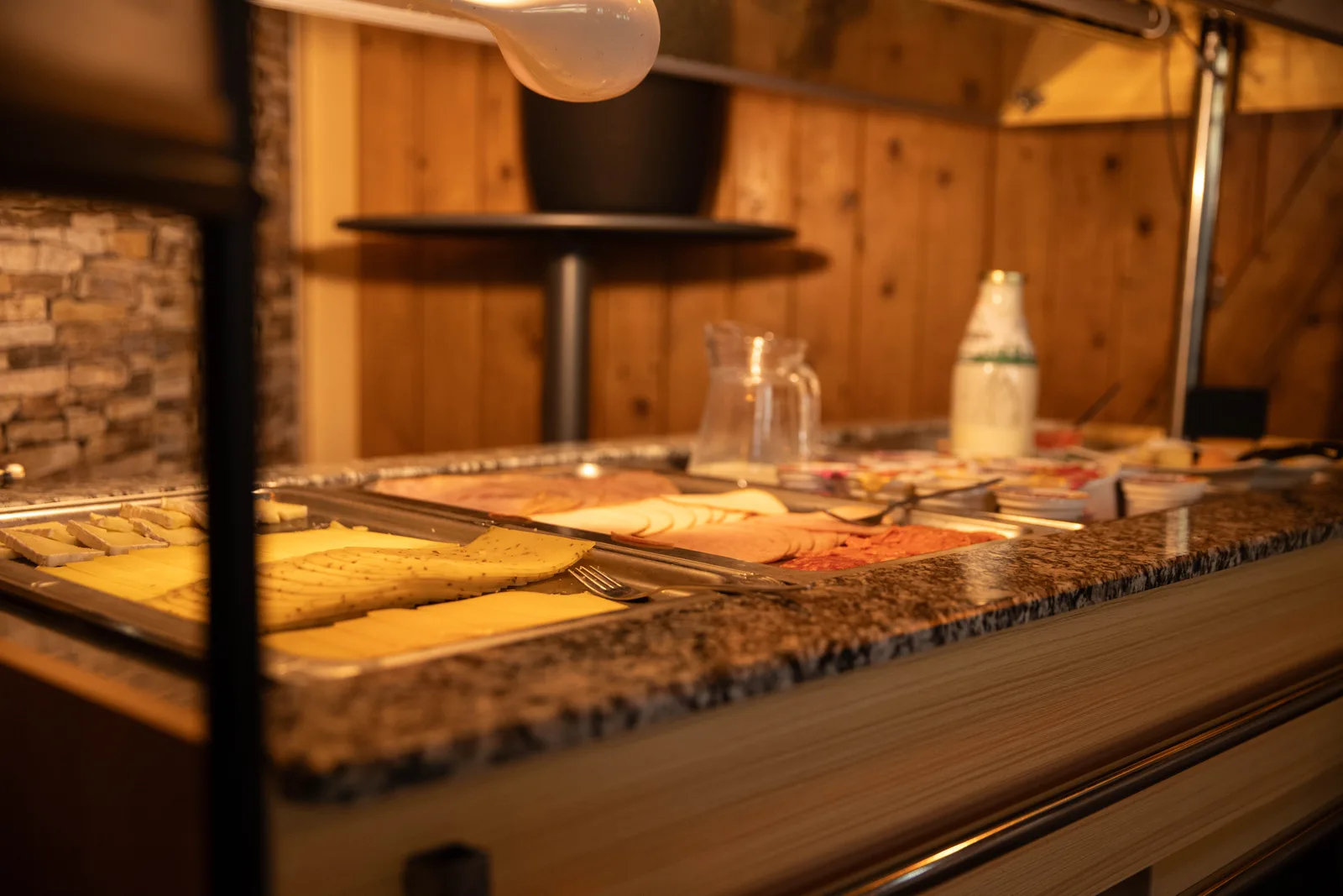 Ontbijtbuffet met schalen kaas en vleeswaren in de verlichte vitrine