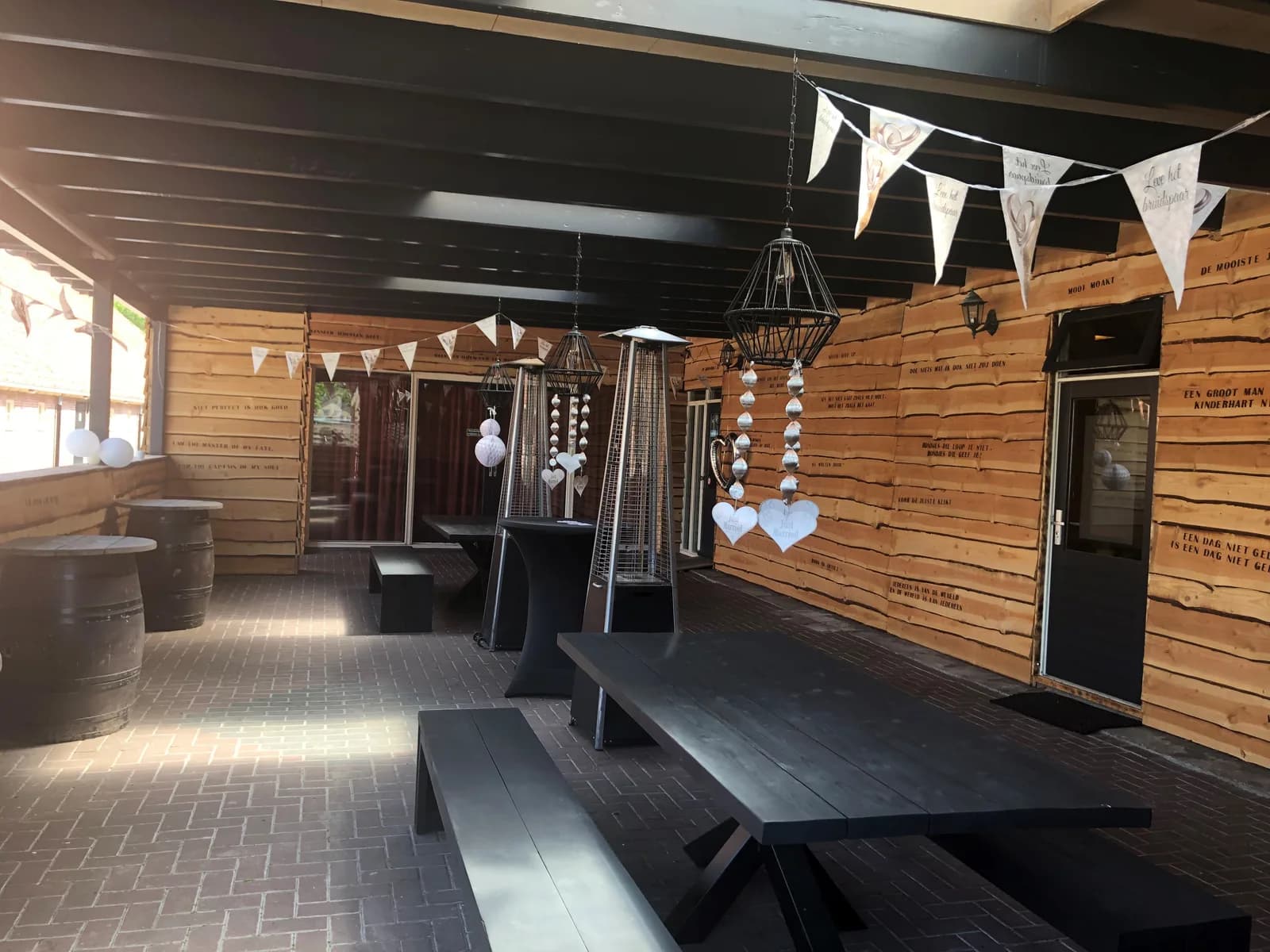 Overdekt terras met vlaggenlijn en lange tafels