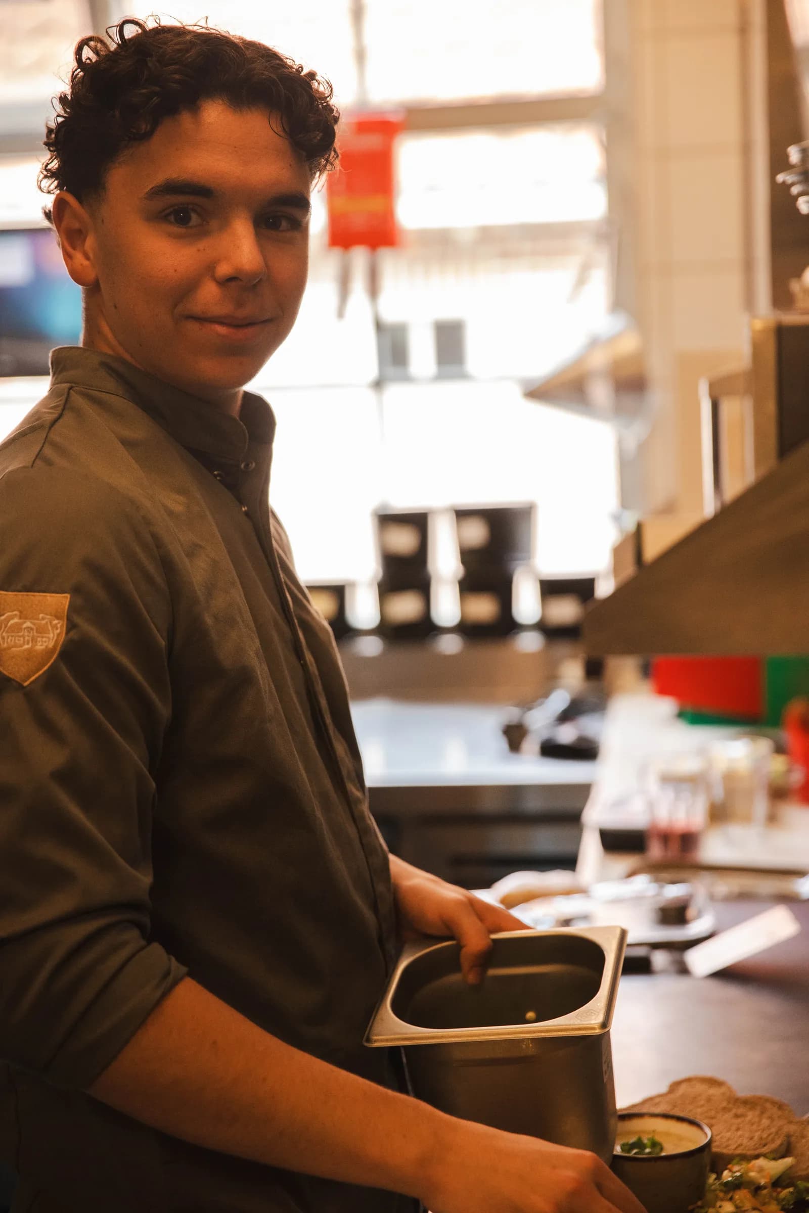 Kok zet een bak klaar aan de doorgeefkeuken tijdens de mise-en-place