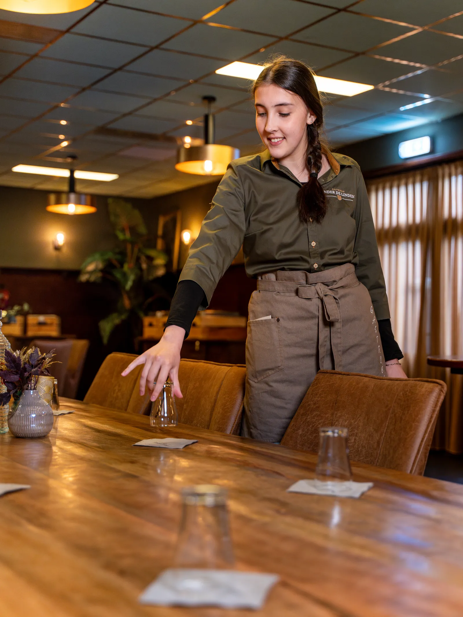 Medewerker dekt een tafel in de zaal
