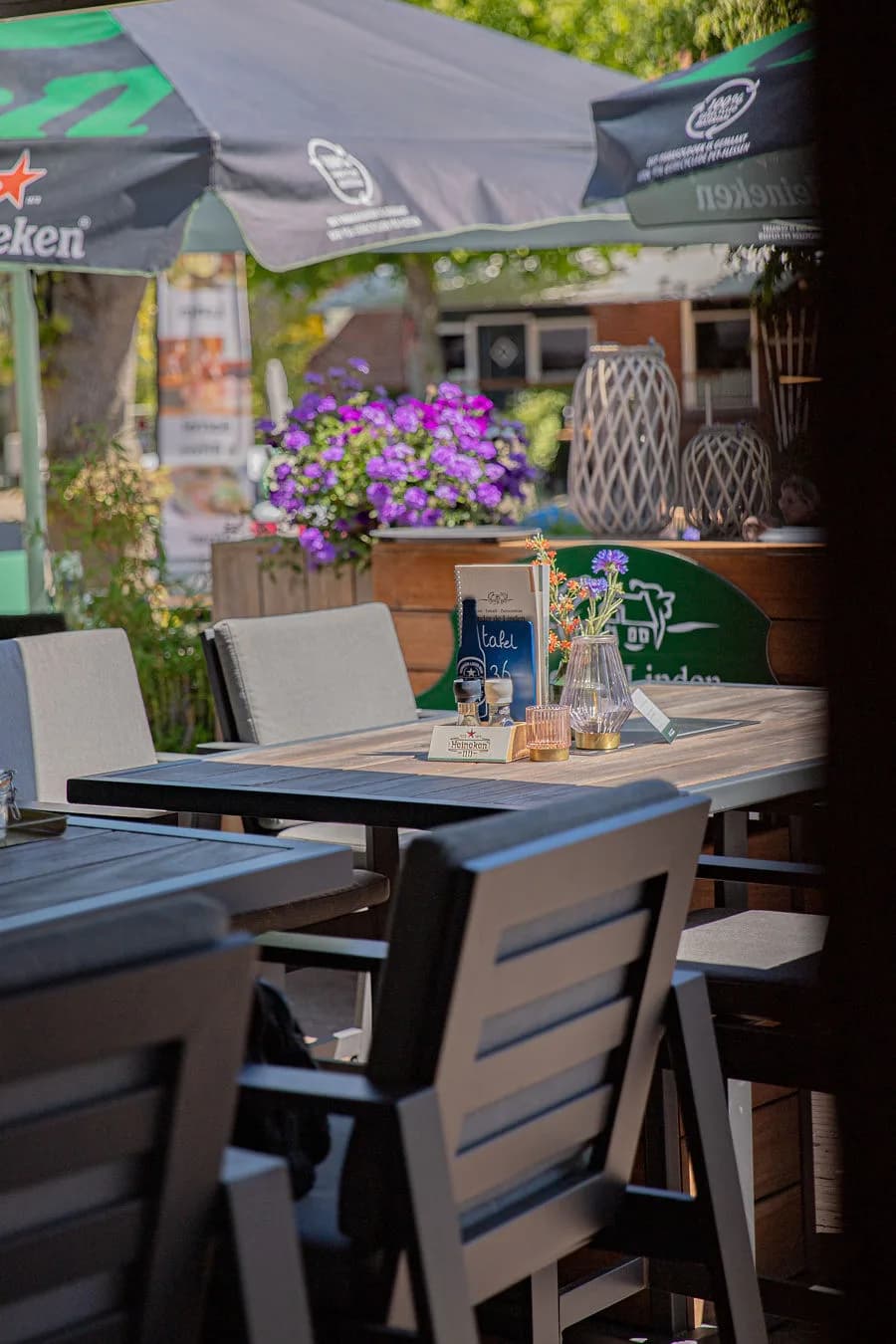Gedekte terrastafel met menukaart onder een parasol