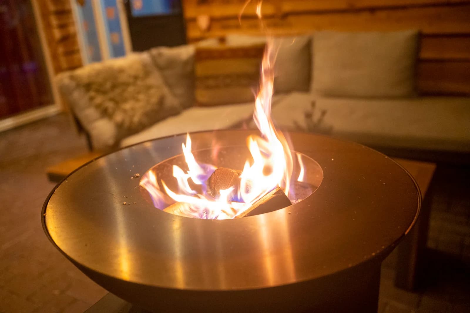 Brandende vuurtafel bij de loungebank op het terras