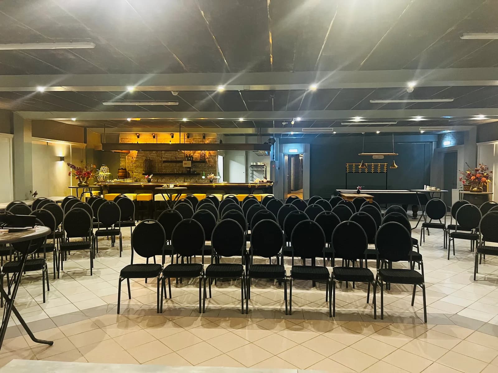 Theateropstelling met rijen stoelen voor de eigen bar van de zaal