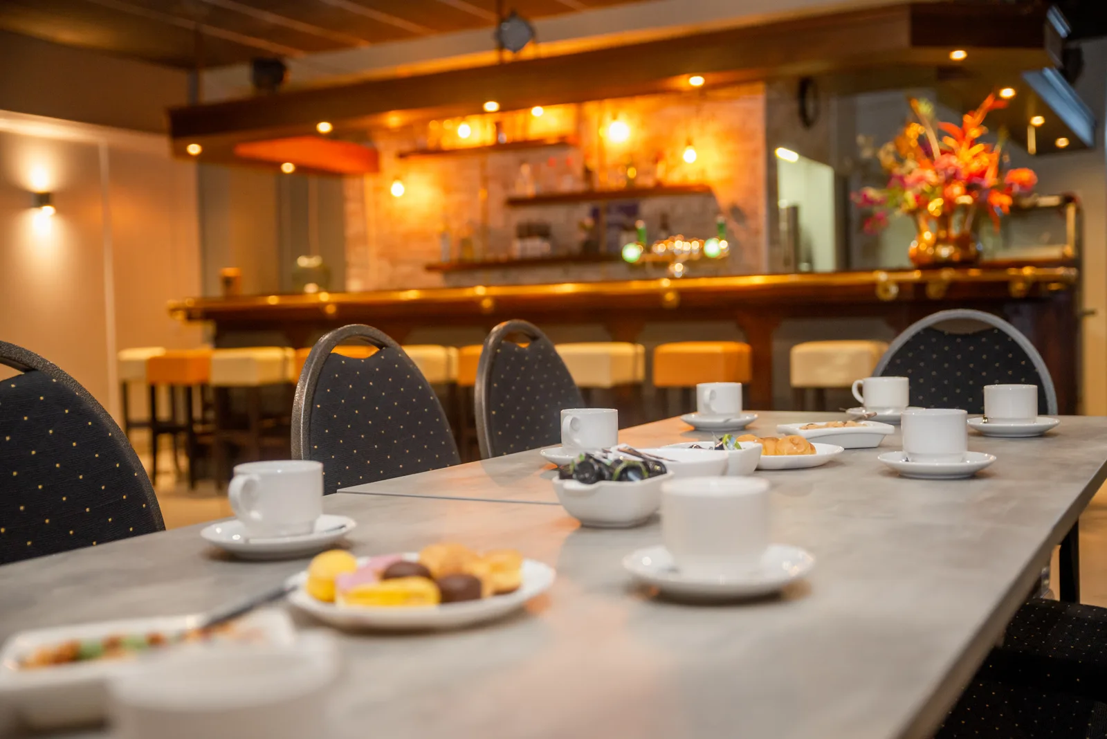 Koffiekopjes en zoete hapjes op tafel in De Linden